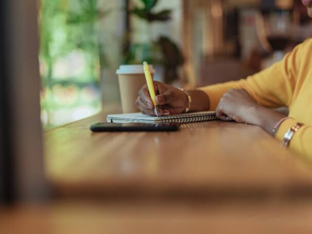 Afro American Woman Writing at a Cafe